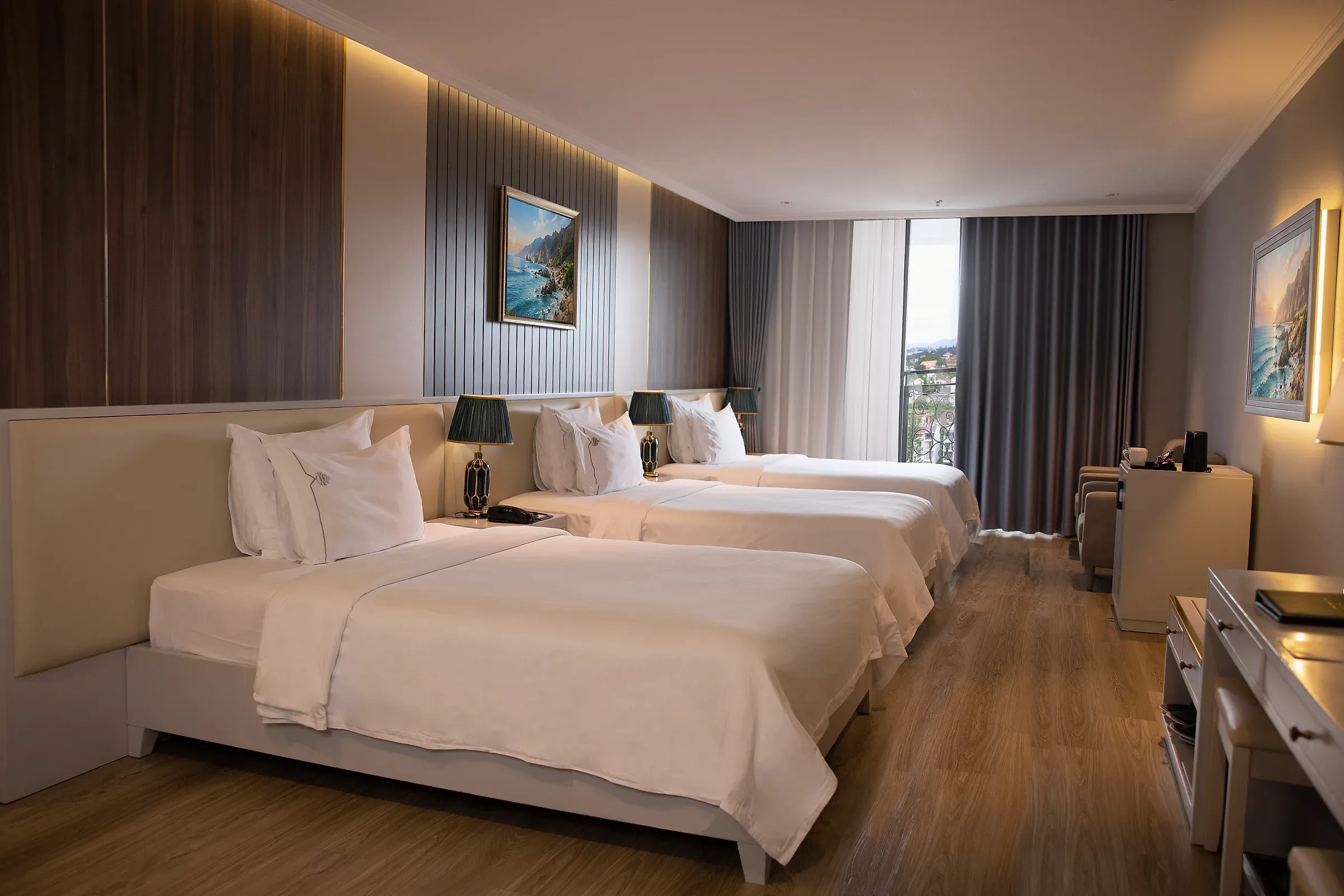 Không gian phòng Deluxe Triple tại MerPerle Đà Lạt với giường trắng và cửa sổ.