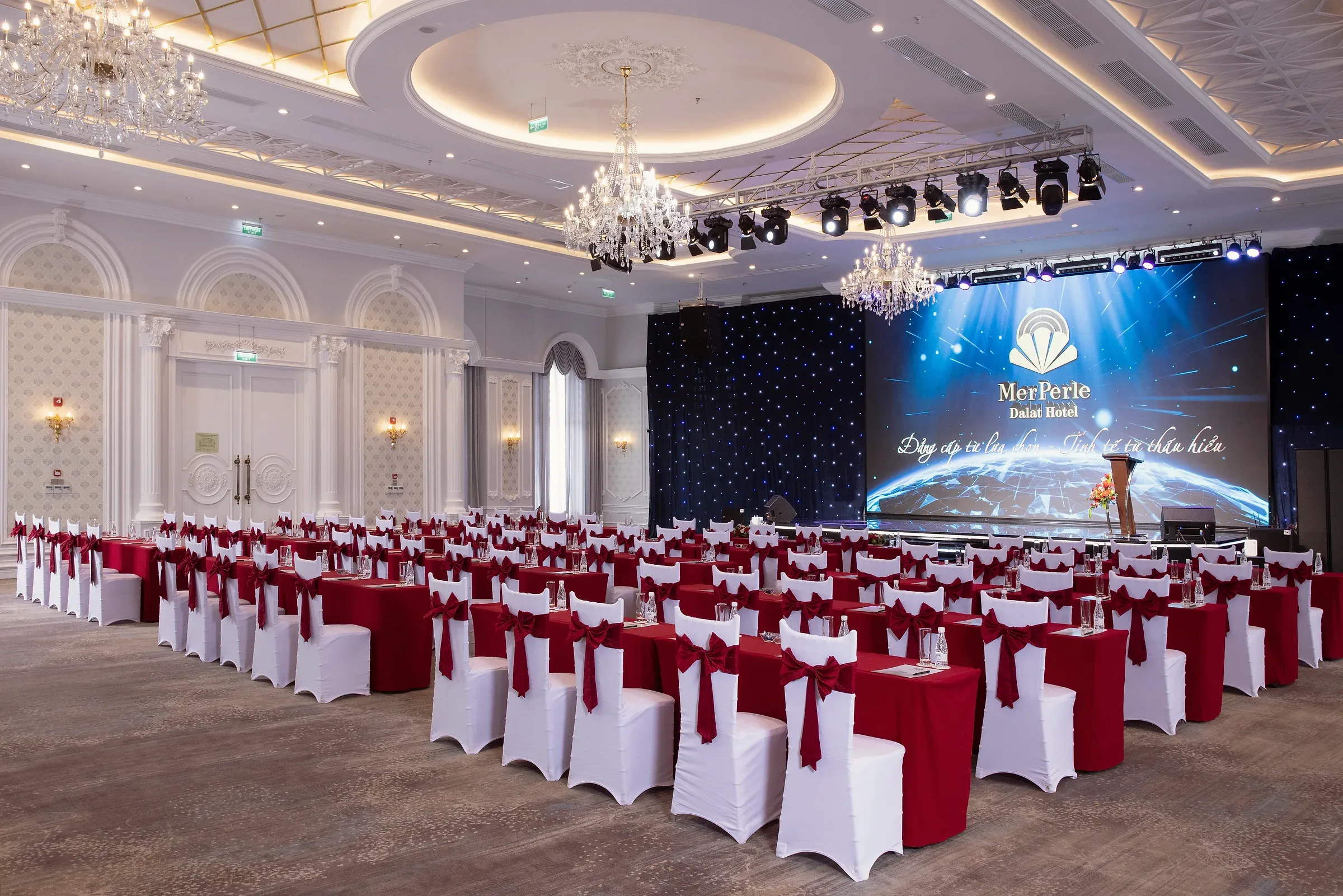 Sảnh Romance xếp bàn kiểu lớp học hướng về sân khấu màn LED tại MerPerle Dalat Hotel