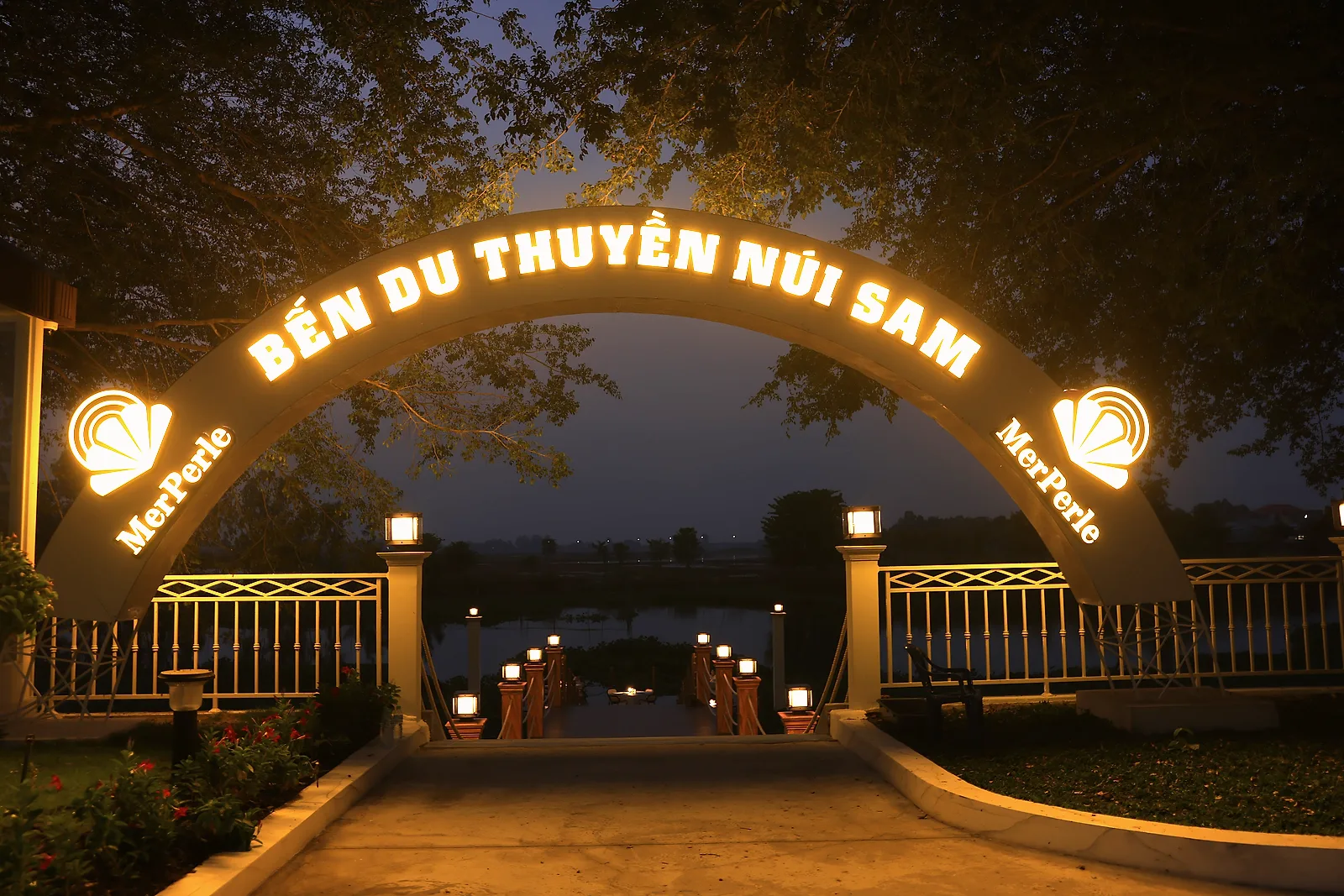 Cổng bến du thuyền của MerPerle Nui Sam Resort sáng đèn, bậc thang dẫn xuống bến sông lúc tối