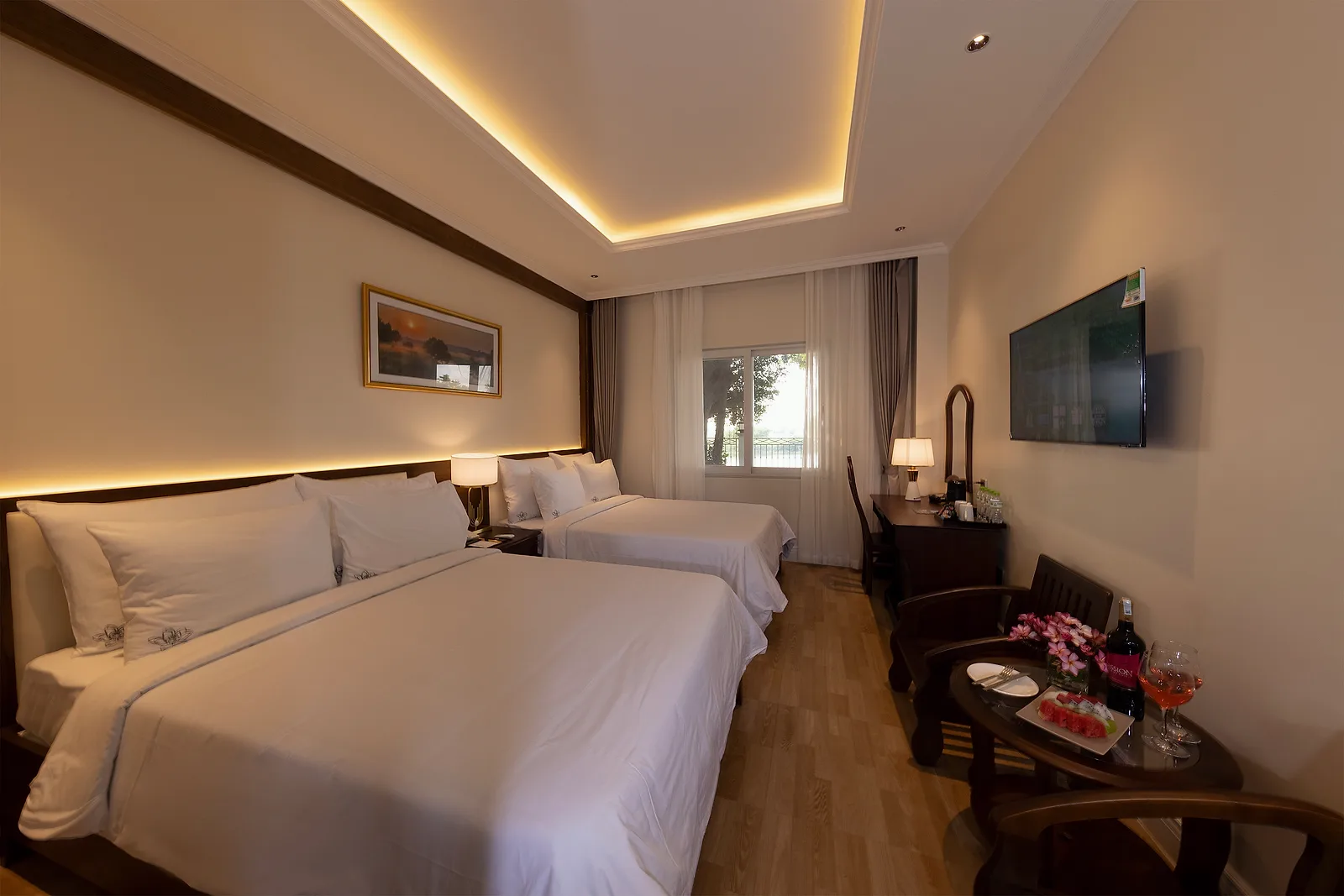 Phòng Deluxe Triple của MerPerle Nui Sam Resort với giường lớn hướng ra cửa sổ